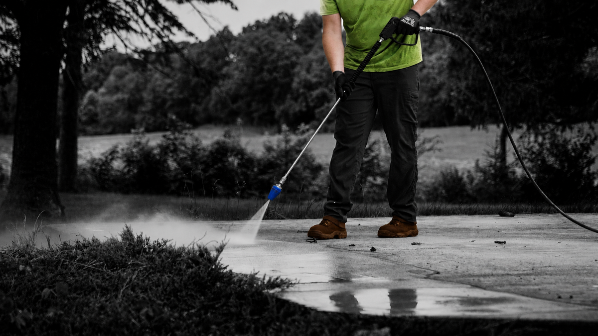 Man Using Blue Aqua Rocket Turbo Nozzle to Pressure Wash Sidewalk