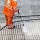 Worker cleaning a street sidewalk with pressurized water. Copy space
