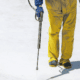 man wearing winter safety equipment pressure washing in the snow